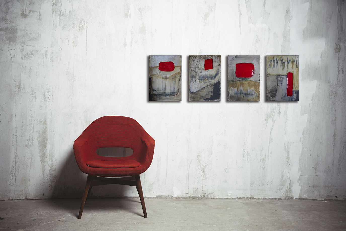 red armchair near the old textured gray wall
